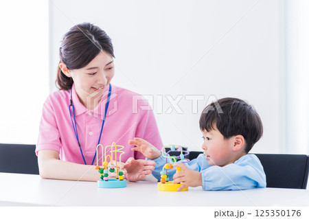 知育玩具でトレーニングする保育園児と保育士 125350176