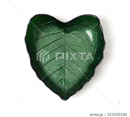 Green glass bowl shaped like a leaf , isolated on white background. Elegant tableware with a nature-inspired design. Green glass bowl shaped like a leaf , isolated on white background. Elegant tableware with a nature-inspired design. 125350190