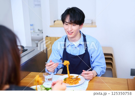 夫が作ったパスタを食べる夫婦のイメージ 125350758