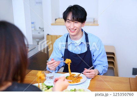 夫が作ったパスタを食べる夫婦のイメージ 夫が作ったパスタを食べる夫婦のイメージ 125350760