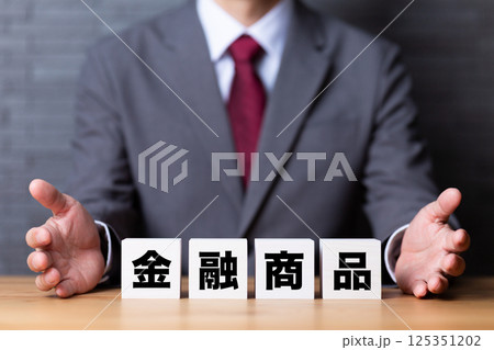金融商品のブロックとスーツを着たミドル男性ビジネスマン 125351202