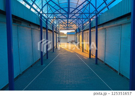Empty closed unmanned commercial metal roller shutters on the modern market. 125351657