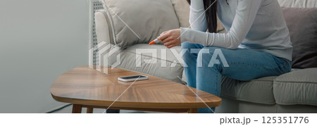 A sad woman holds a pregnancy test in her hand. Unwanted pregnancy concept. A sad woman holds a pregnancy test in her hand. Unwanted pregnancy concept. 125351776