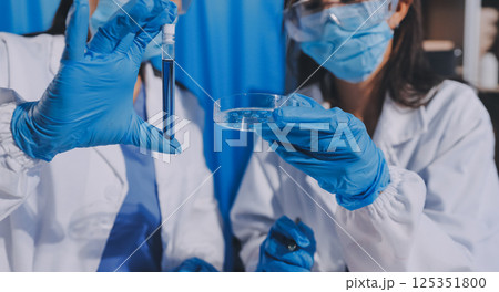 Researcher using a professional microscope 125351800