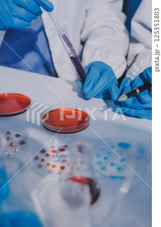 Researcher using a professional microscope Researcher using a professional microscope 125351803