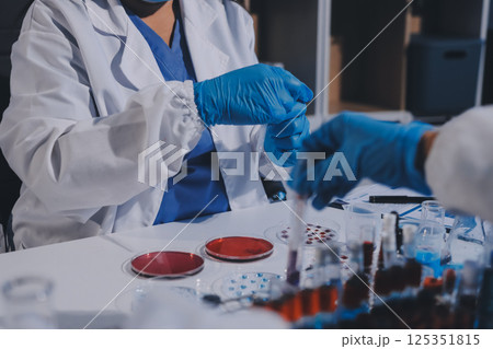 Researcher using a professional microscope 125351815