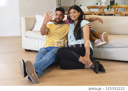 Happy family relaxing on living room floor, enjoying quality time together Happy family relaxing on living room floor, enjoying quality time together 125352222