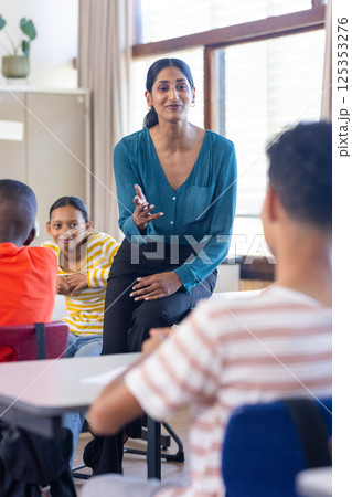 In school, Indian female teacher engaging with students, fostering interactive learning environment 125353276