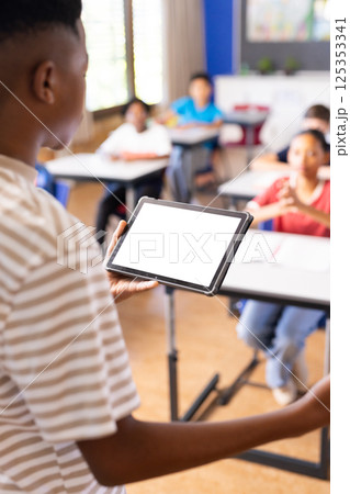 In school, student presenting using tablet in classroom with classmates watching, copy space In school, student presenting using tablet in classroom with classmates watching, copy space 125353341