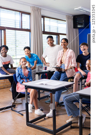 Group of students and Indian female teacher smiling in classroom, enjoying school environment 125353345