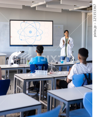 Explaining science concept in school, indian female teacher with students using microscopes Explaining science concept in school, indian female teacher with students using microscopes 125353367