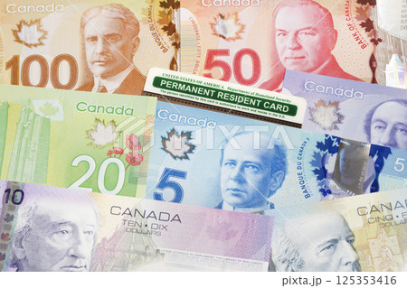 American permanent resident card on a Canadian money American permanent resident card on a Canadian money 125353416