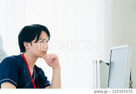 データを見て話し合う男性医師たち 125353575