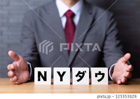 NYダウのブロックとスーツを着たミドル男性ビジネスマン NYダウのブロックとスーツを着たミドル男性ビジネスマン 125353829
