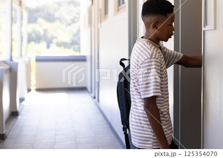 Opening locker, student with backpack in school hallway, preparing for class, copy space Opening locker, student with backpack in school hallway, preparing for class, copy space 125354070