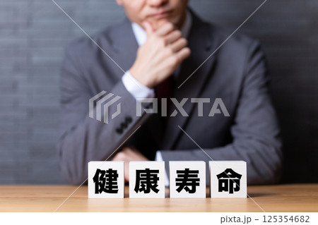 健康寿命のブロックとスーツを着て悩むミドル男性ビジネスマン 健康寿命のブロックとスーツを着て悩むミドル男性ビジネスマン 125354682