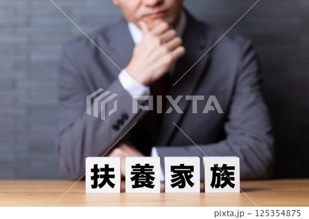 扶養家族のブロックとスーツを着て悩むミドル男性ビジネスマン 125354875