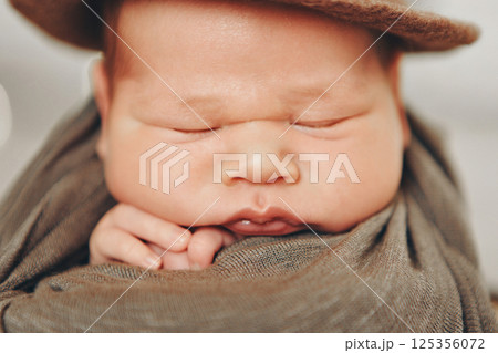 A newborn baby is wrapped in diapers with a wool cap in a basket. Swaddling, maternity hospital, family, ivf, life planning, parenting. A mother's love for her child. Baby food. High quality photo 125356072