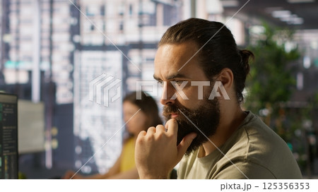 Pensive employee using computer to analyze datasets, focused on comparing datasets and checking accounting figures. Close up of man concentrating on solving tasks for team project, camera A 125356353