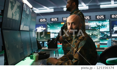 Military officers checking weapons in control room, ensuring bullets and supplies are properly and evenly distributed. Soldiers managing combat load equipment before warfare assault mission, camera B Military officers checking weapons in control room, ensuring bullets and supplies are properly and evenly distributed. Soldiers managing combat load equipment before warfare assault mission, camera B 125356374