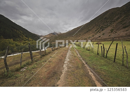 Road track with wooden fences in the mountains Road track with wooden fences in the mountains 125356583