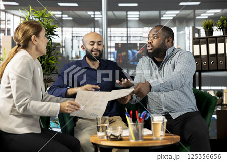 Angry employee in office destroying relationship with business partners, yelling at them, unhappy with work done. Upset manager berating shareholders, displeased by low investments Angry employee in office destroying relationship with business partners, yelling at them, unhappy with work done. Upset manager berating shareholders, displeased by low investments 125356656