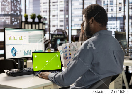 Professional employee analyzing business data on pc next to copy space screen, financial planning and budgeting supports company goals. Effective general management within the enterprise. 125356809