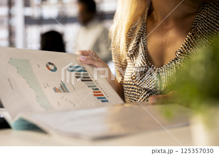 Corporate businesswoman reviewing data analytics at work, doing report writing to ensure project progress. Multinational company worker managing deadlines and financial planning. Close up. Corporate businesswoman reviewing data analytics at work, doing report writing to ensure project progress. Multinational company worker managing deadlines and financial planning. Close up. 125357030