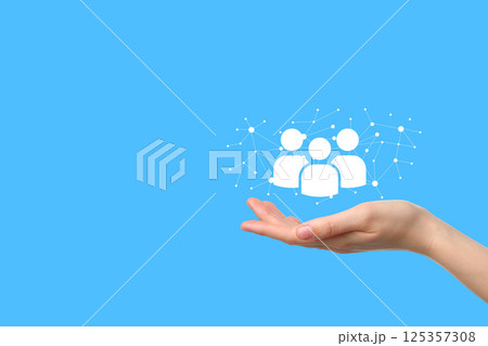 A hand holds user icons, symbolizing digital connection and social interaction A hand holds user icons, symbolizing digital connection and social interaction 125357308