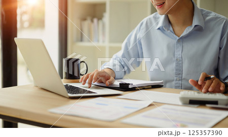 Close up of business analyst calculating financial data at desk 125357390