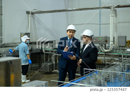 Two business professionals reviewing operations in a food production facility 125357487