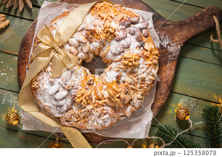 Bolo Rainha, a celebratory ring cake garnished with almonds, nuts, dried fruits, fruits raisins and dusted with powdered sugar, perfect for festive occasions like Christmas and New Year. Top view 125358078