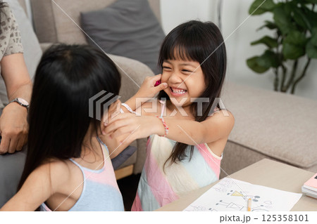 Sisterhood and Playfulness. Two girls embracing each other while enjoying art activities. Sisterhood and Playfulness. Two girls embracing each other while enjoying art activities. 125358101