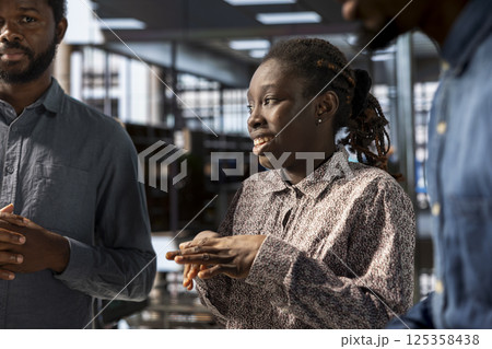 African american corporate staff gathered to brainstorm solutions, working together to review reports for business growth. Colleagues meeting and sharing insight on actionable successful strategies. African american corporate staff gathered to brainstorm solutions, working together to review reports for business growth. Colleagues meeting and sharing insight on actionable successful strategies. 125358438