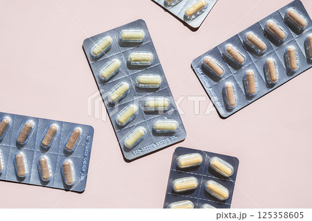 Multiple Blister Packs Filled with Translucent Drug Dose Capsule on Pink Background. Medication, Pharmacy and Health Concepts. Multiple Blister Packs Filled with Translucent Drug Dose Capsule on Pink Background. Medication, Pharmacy and Health Concepts. 125358605