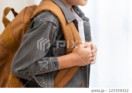Back to School Essentials. A child preparing for school with a stylish backpack. 125359322
