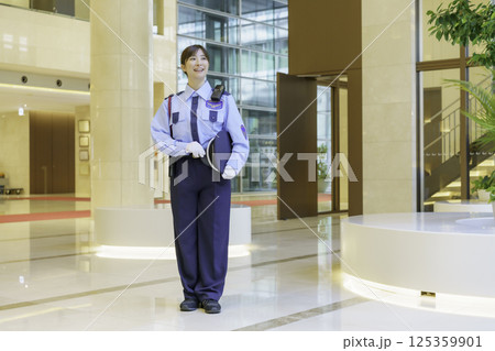 オフィスビルのロビーに立つ若い女性警備員 撮影協力:学校法人電波学園 東京電子専門学校 オフィスビルのロビーに立つ若い女性警備員 撮影協力:学校法人電波学園 東京電子専門学校 125359901