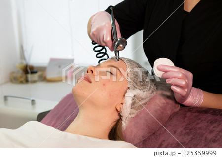 Esthetician uses airbrush device to spray facial mist 125359999