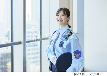 窓際に立つ若い女性警備員のポートレート　撮影協力：学校法人電波学園 東京電子専門学校 125360356