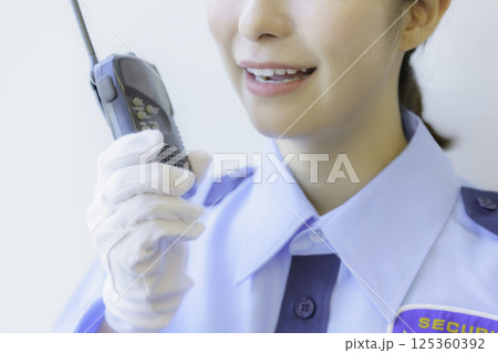 トランシーバーで会話する若い女性警備員の口元のアップ 撮影協力:学校法人電波学園 東京電子専門学校 トランシーバーで会話する若い女性警備員の口元のアップ 撮影協力:学校法人電波学園 東京電子専門学校 125360392