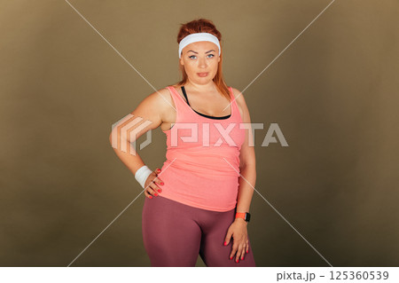 A woman in pink tank top and purple pants poses for a photo 125360539