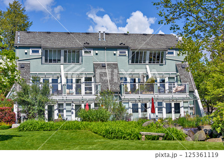 Quadruplex residential building of townhouses on sunny summer day 125361119