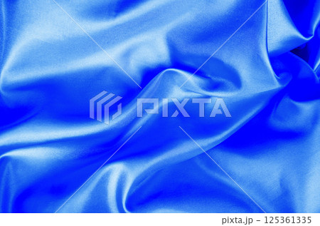 Light blue color silk in soft, smooth waves with a glossy finish. Suitable for design and wallpaper background. Light blue color silk in soft, smooth waves with a glossy finish. Suitable for design and wallpaper background. 125361335