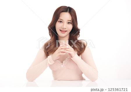 A beautiful young Asian woman with clean, fresh skin against a white background. Skincare, facial treatment, cosmetology, beauty, and spa. An elegant portrait of an Asian woman. 125361721
