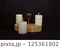 three burning candles on the oak stand with a glass of homemade strong drink  in the dark on the eve of the Christian Easter holiday in spring 125361802