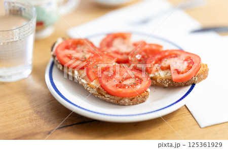 Two bruschettas with tomato slices on a plate Two bruschettas with tomato slices on a plate 125361929