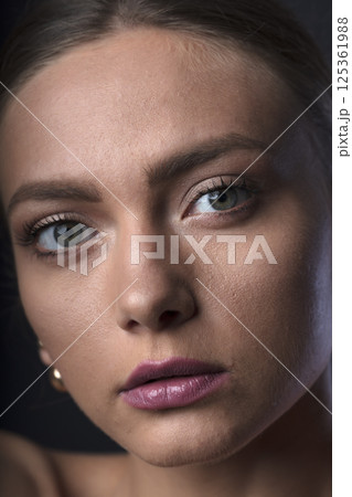 portrait of a young beautiful woman on a dark background 125361988