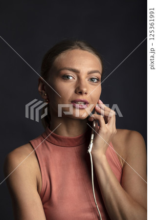 portrait of a young beautiful woman on a dark background portrait of a young beautiful woman on a dark background 125361991