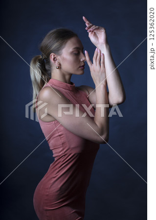 portrait of a young beautiful woman on a dark background 125362020