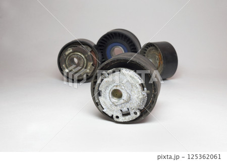 timing belt tensioner roller close-up, all others rollers of car drive and timing mechanism are out of focus in background 125362061